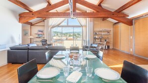 A dining area with a glass table, chairs, and a view of the outdoors.