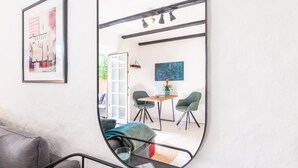 A modern interior with a large mirror reflecting a dining area, a sofa, and a staircase. - Inselkind - Appartement Inselkind (Sylt-Ost)