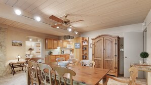 A spacious dining area with a wooden table and chairs, a ceiling fan, and wooden cabinets. - Stonebridge Condos #717 2 Bedrooms, 2 Baths, 2 Fireplaces (Snowmass Village)