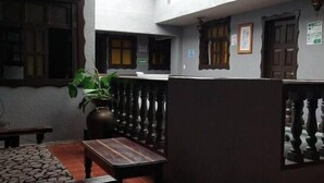 A room with a high ceiling, a skylight, a potted plant, a wooden table, and a bench.