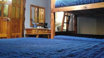 Dormitorio con literas, cómoda de madera, espejo y luz en el techo.