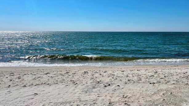 A beach with visible footprints and waves.
