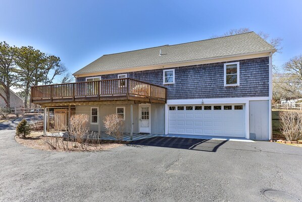 A two-story house with a covered porch and a garage. - Beautiful Chatham, Sun Sand & Surf. 8/10 mile to beaches ,pet friendly home (Chatham)
