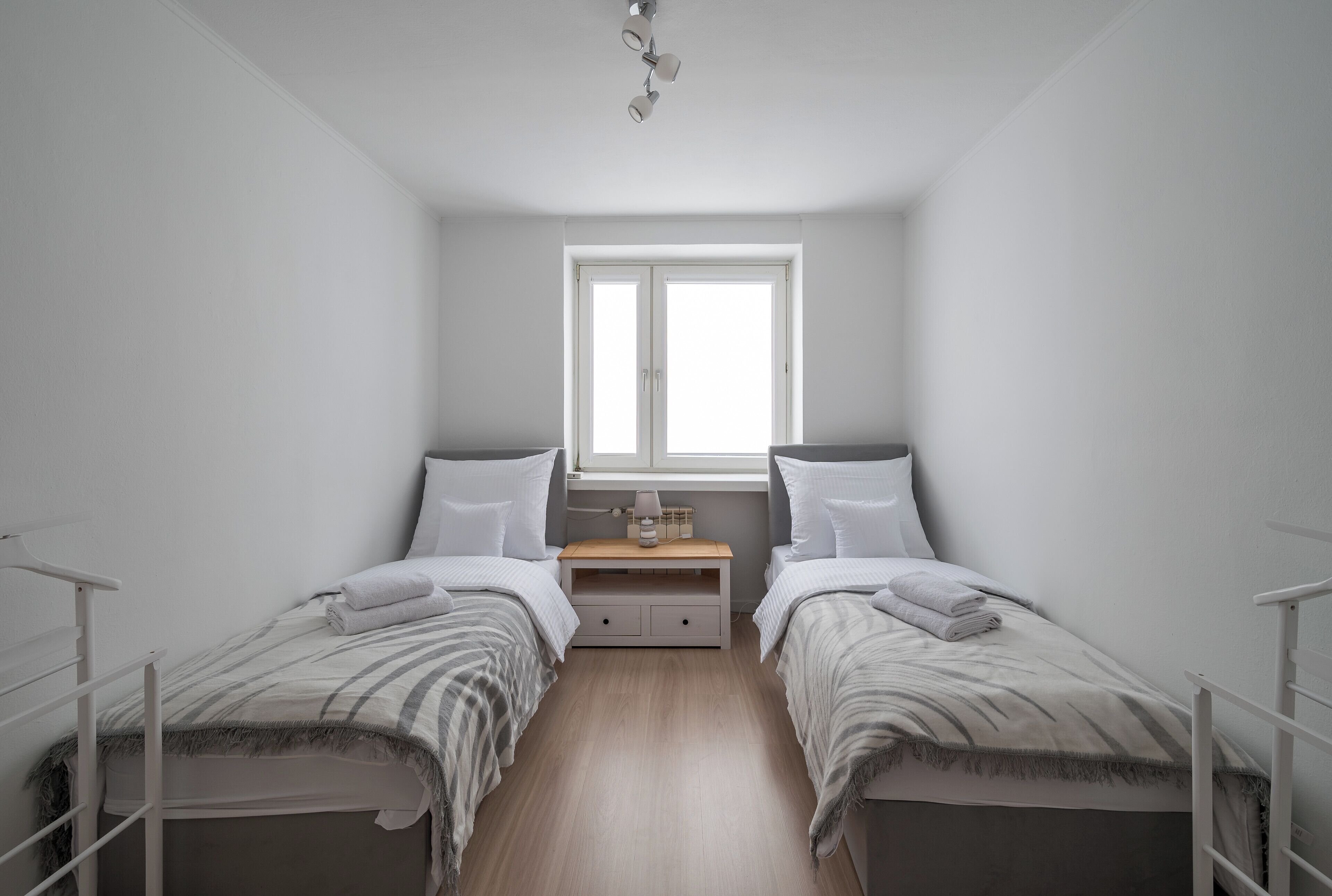 Ein Doppelzimmer mit zwei Betten, einem kleinen Nachttisch und einem Fenster.