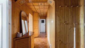 A wooden hallway with a tiled floor, wooden cabinets, and a door with hooks. - National Stadium Comfy Apartment (Warszawa)
