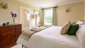 A bedroom with a large bed, a dresser, a mirror, and a window with curtains. - Auchengashell - sleeps 8 guests  in 4 bedrooms (Kirkcudbright)