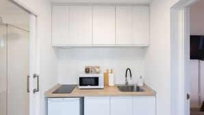 A compact kitchen with white cabinets, a microwave, a sink, and a small dishwasher. - Casa Checha Charming Penthouse With Breathtaking Views (Candelaria)