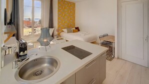 A compact hotel room with a kitchenette, a bed with a view, and a small dining area. - Upstays Studio Top Floor Sea View Cannes (Cannes)