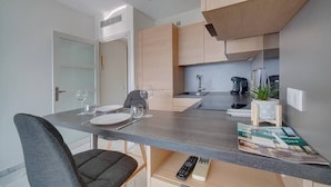 Una cocina moderna con encimera gris, armarios de madera y una pequeña planta en maceta.