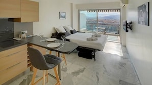 Una habitación de hotel moderna con cama, zona de comedor y cocina.