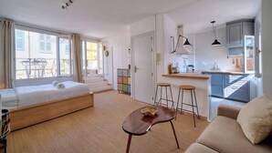 A modern, compact living space with a bed, a small dining area, and a kitchenette. - Upstays Banane Terrace 30m² Studio (Cannes)