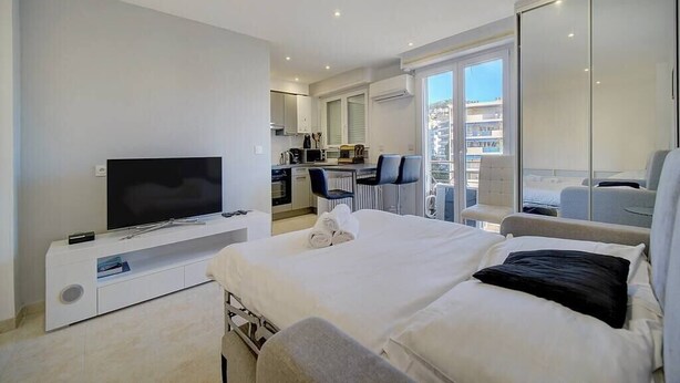 Une chambre d’hôtel moderne dotée d’un grand lit, d’une télévision, d’un bureau et d’un balcon avec vue.