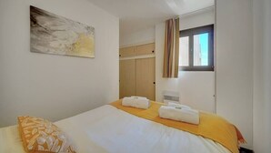 A hotel room with a bed, a painting on the wall, a wardrobe, and a window with curtains. - Upstays Terrace Pool Parking 40m² Apartment (Cannes)