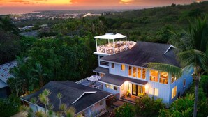 A two-story house with a covered patio and a view of the surrounding landscape. - Roof deck views, hot tub, big kitchen, 3200sf, BBQ (Kailua-Kona)