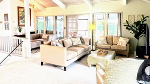 A spacious living room with high ceilings and large windows, furnished with multiple sofas and a coffee table. - Roof deck views, hot tub, big kitchen, 3200sf, BBQ (Kailua-Kona)