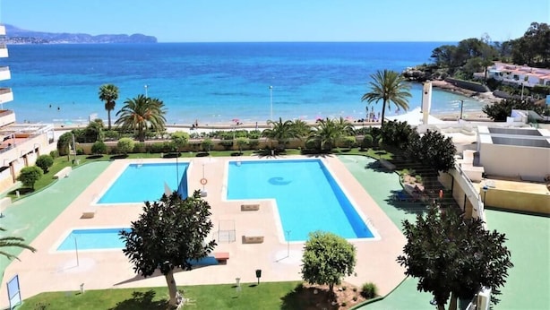 Un complexe hôtelier doté d’une grande piscine, d’une plage et offrant une vue sur la mer.