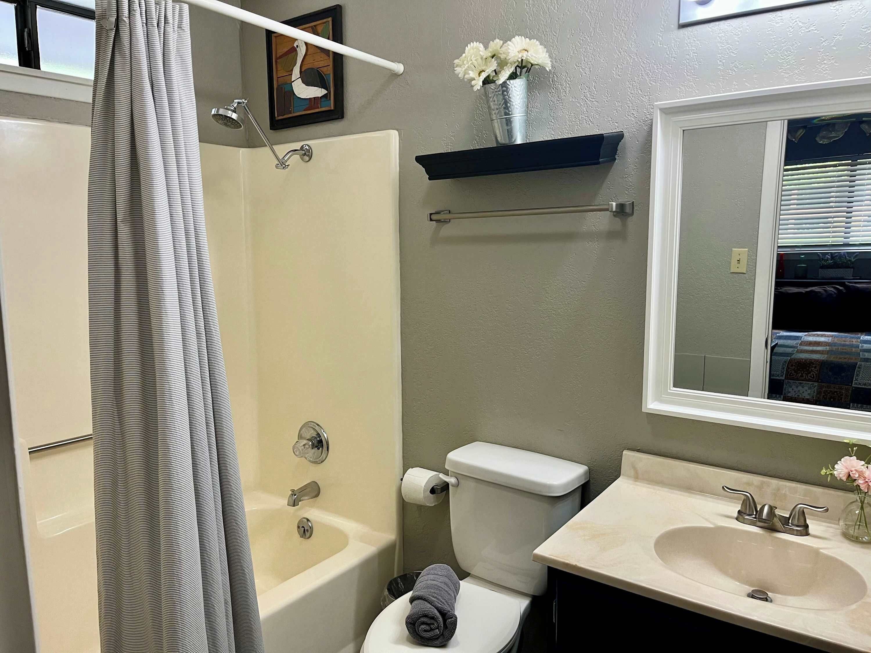 Une salle de bain équipée d’une baignoire, de toilettes, d’un lavabo et d’un miroir.