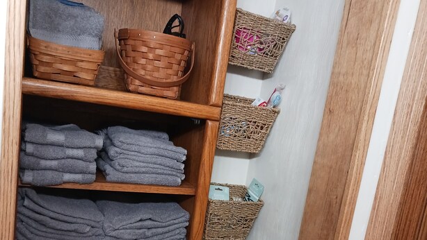 A wooden shelf with folded towels and wicker baskets. - Work crews welcome! near the I-71/Rt 13 and I-71/Rt 39  easy access to Mansfield (Mansfield)