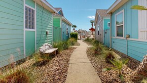Un étroit sentier bordé de bâtiments à deux étages, avec un ciel dégagé au-dessus.