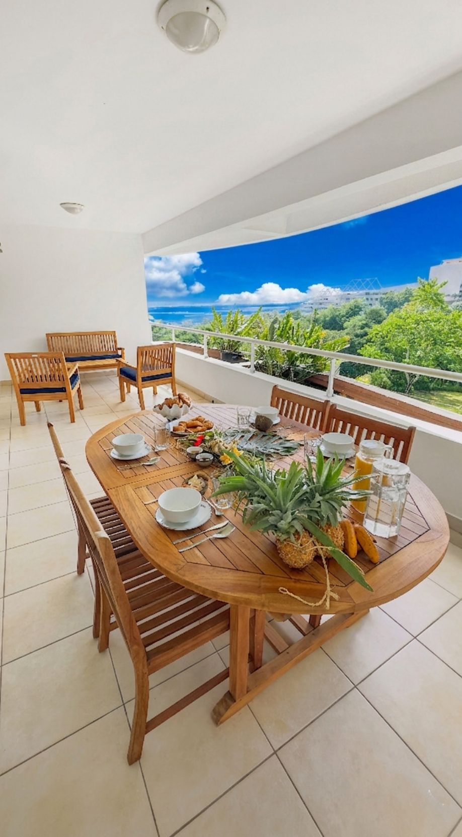 A dining area with a round wooden table set for four, surrounded by wooden chairs.