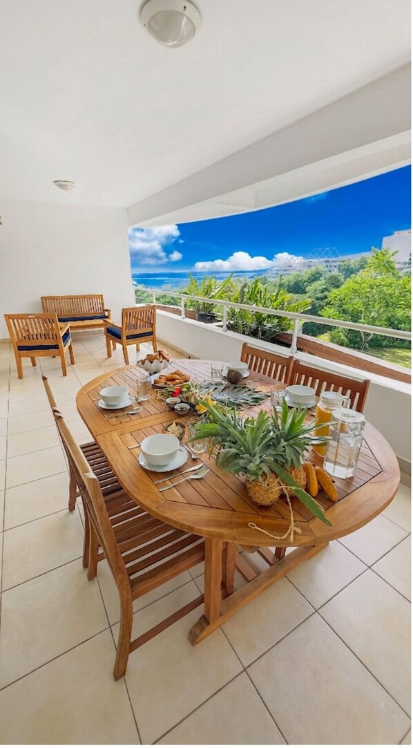 A dining area with a round wooden table set for four, surrounded by wooden chairs.