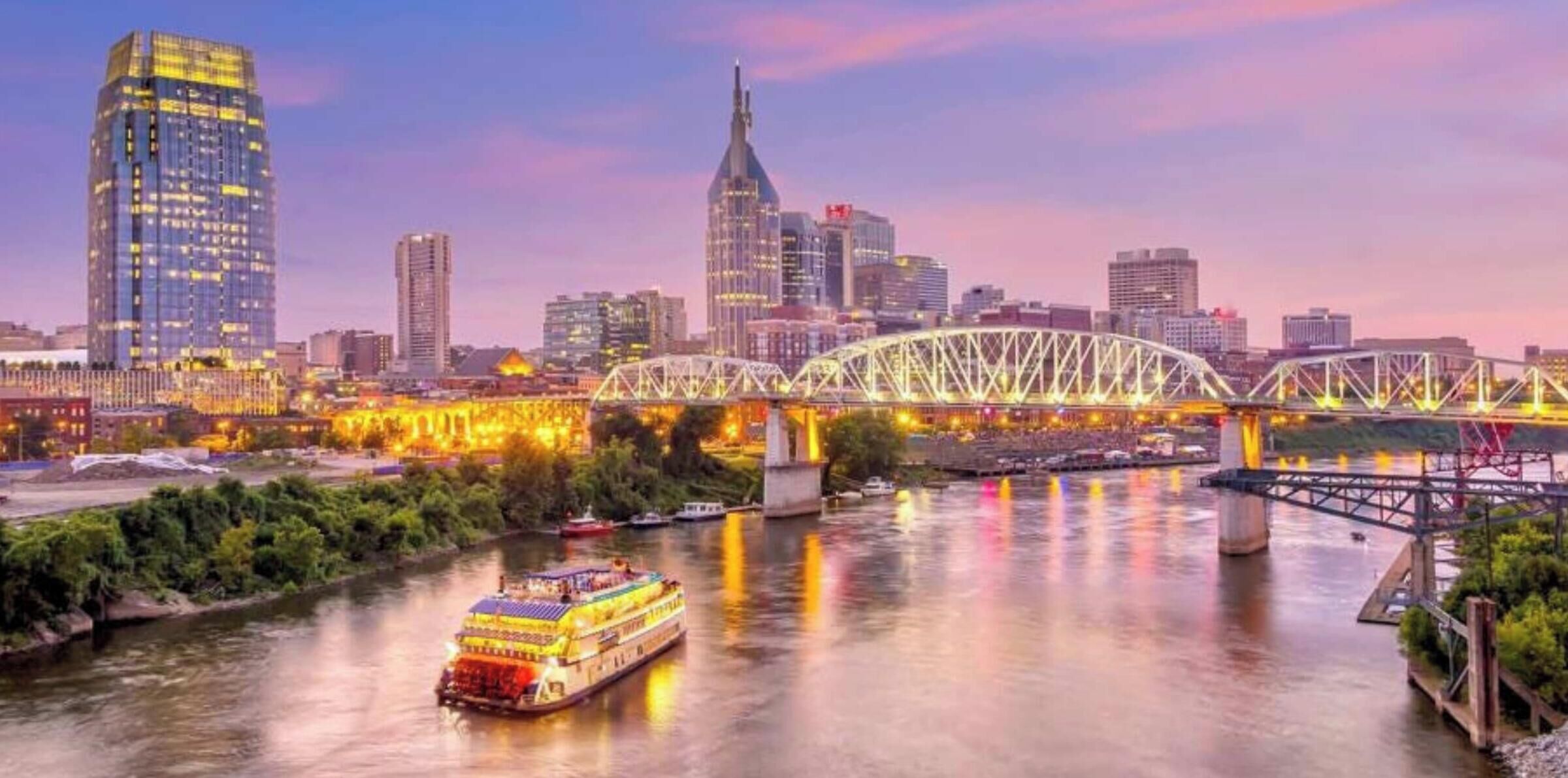 A cityscape with a river, a bridge, and a boat.