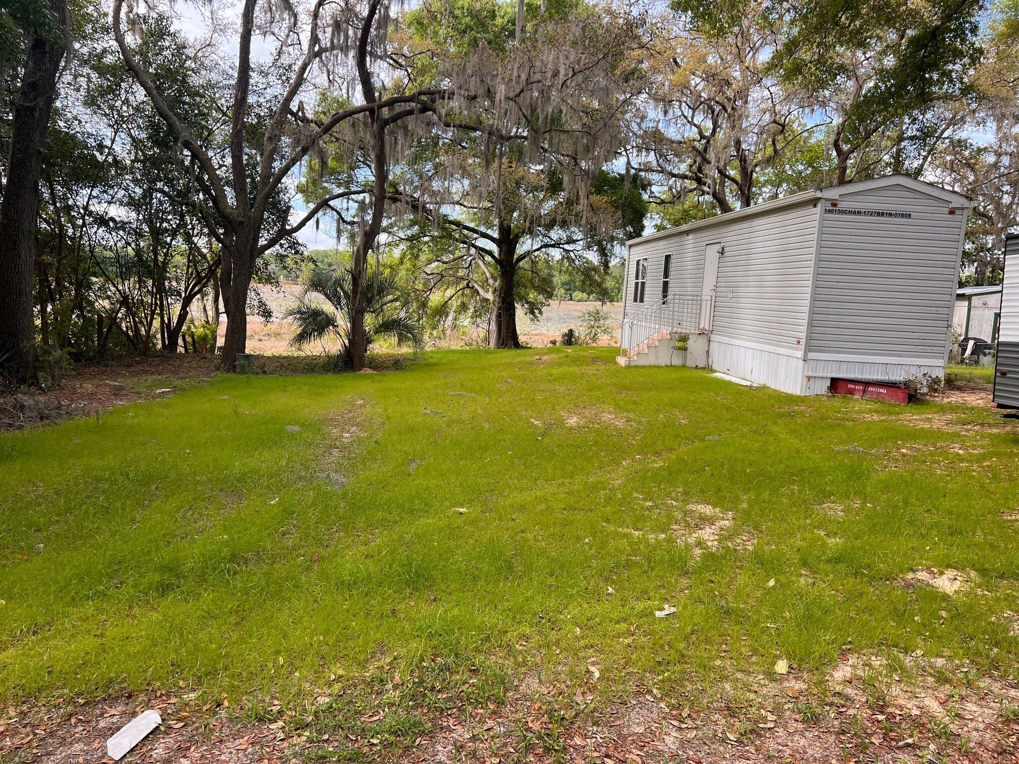 A small, single-story house with a covered porch and a grassy yard.
