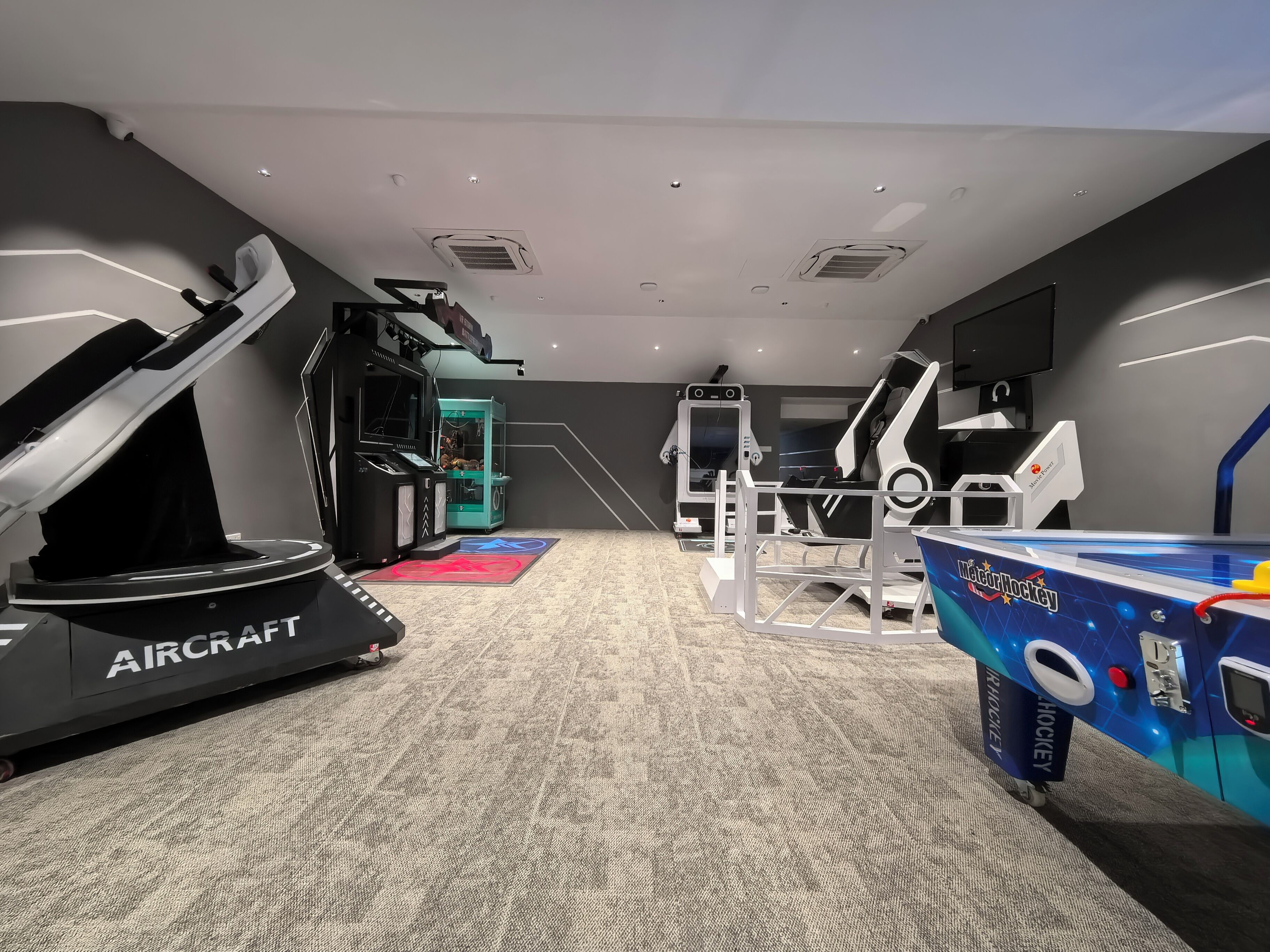 Een moderne sportschool met loopbanden, trainingsapparatuur en een speelruimte met een ijshockeythema.