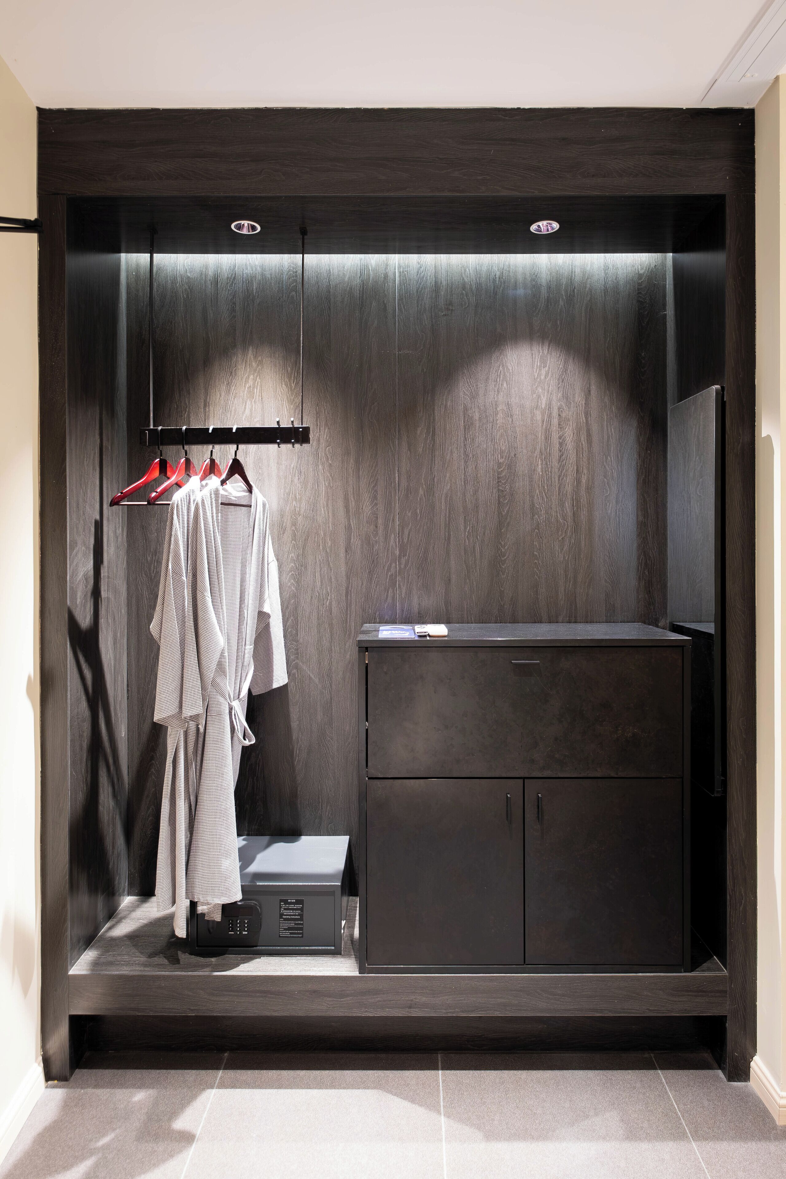 A modern bathroom with a dark wood vanity, a robe rack, and a towel rack.