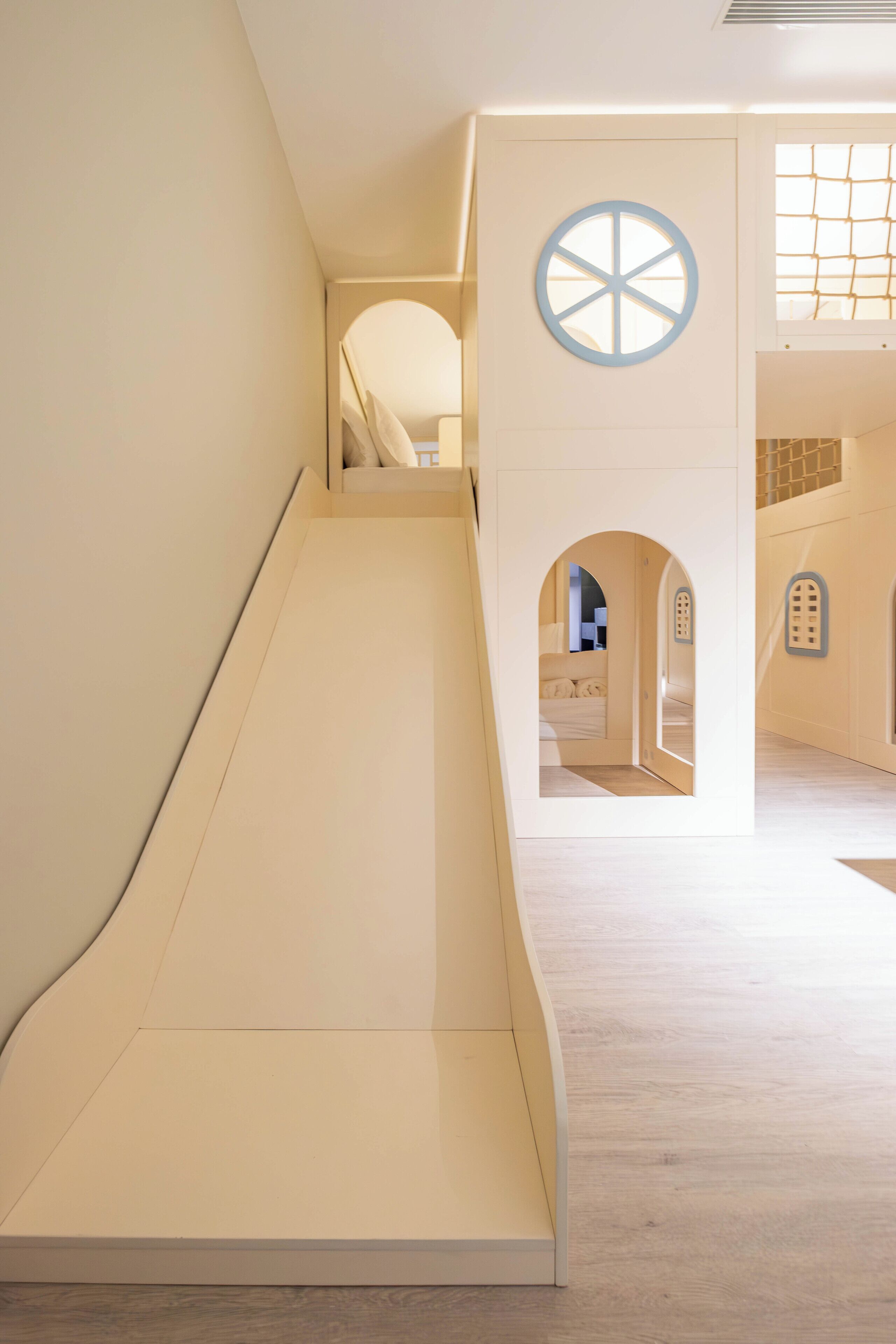 A children's play area with a slide and arched doorways.