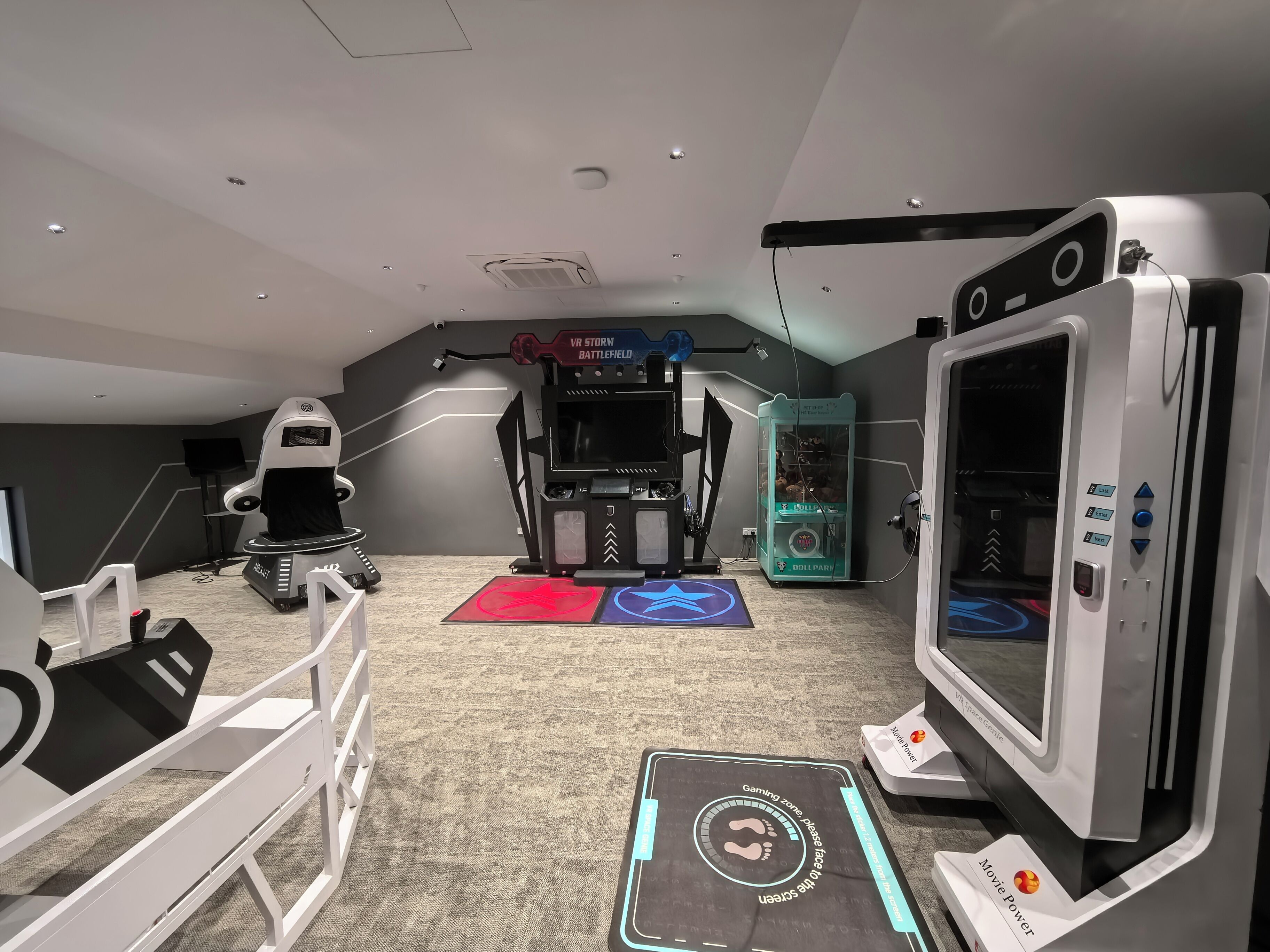 A VR gaming room with a treadmill, a treadmill with a VR headset, a VR gaming console, and a treadmill with a VR headset.