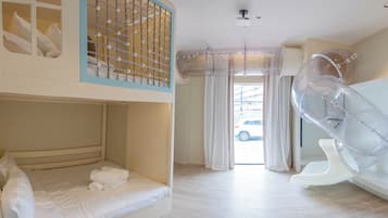 A room with bunk beds, a sliding ladder, and a large window with curtains.