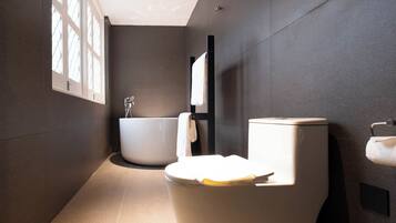 Ein modernes Badezimmer mit Toilette, Badewanne und Handtuchhalter.