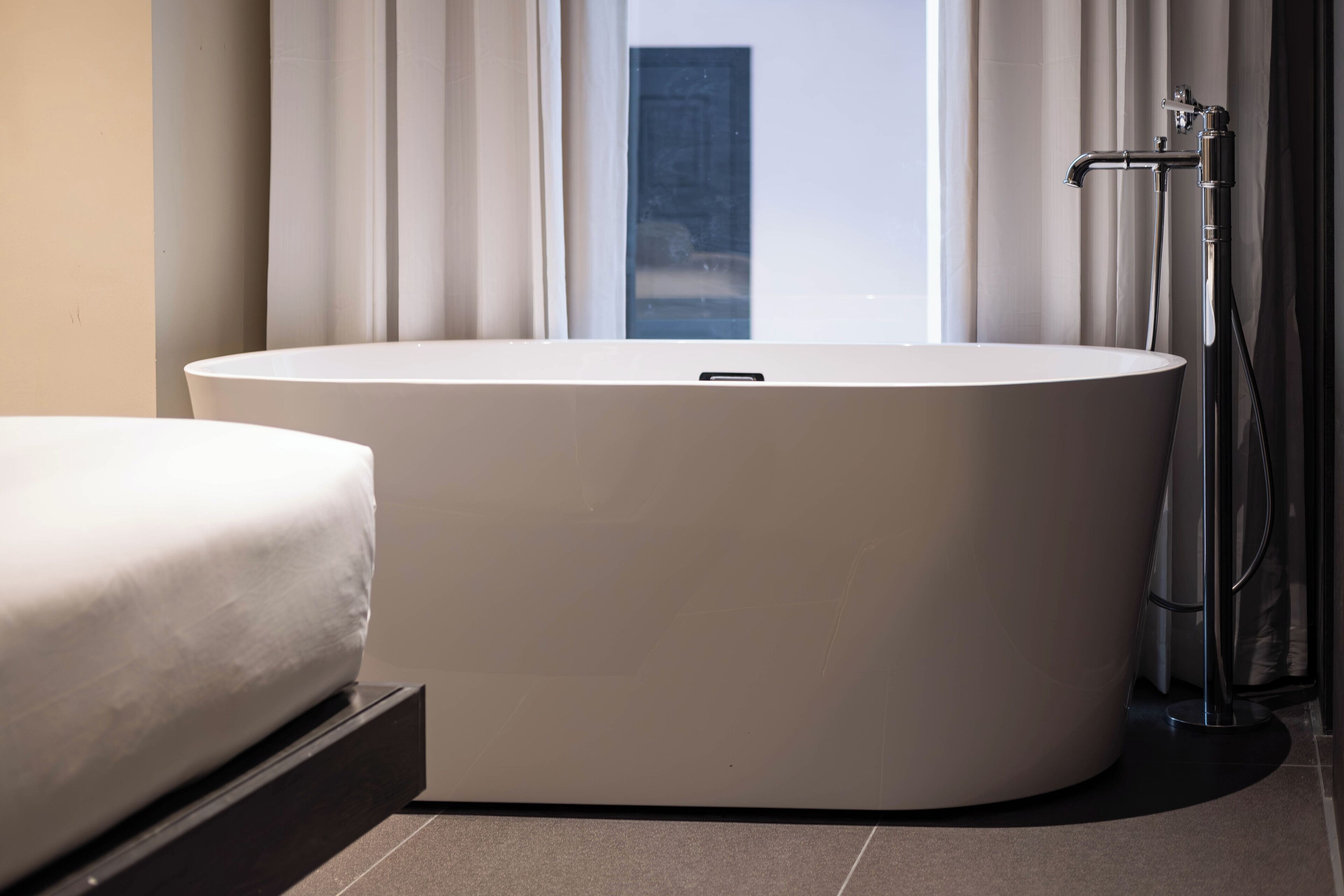 Un baño moderno con una bañera independiente, inodoro y zona de ducha.
