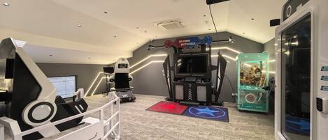 A VR gaming room with a VR chair, a treadmill, and a VR boxing machine.