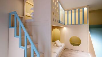 A modern interior with a staircase, a bunk bed, and a small seating area.