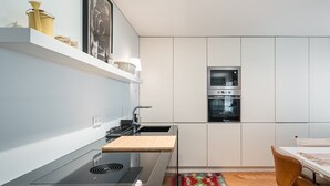 A modern kitchen with a built-in oven, a stove, and a sink. - GuestReady - Relaxing duplex near Parque da Cidade (Senhora da Hora)
