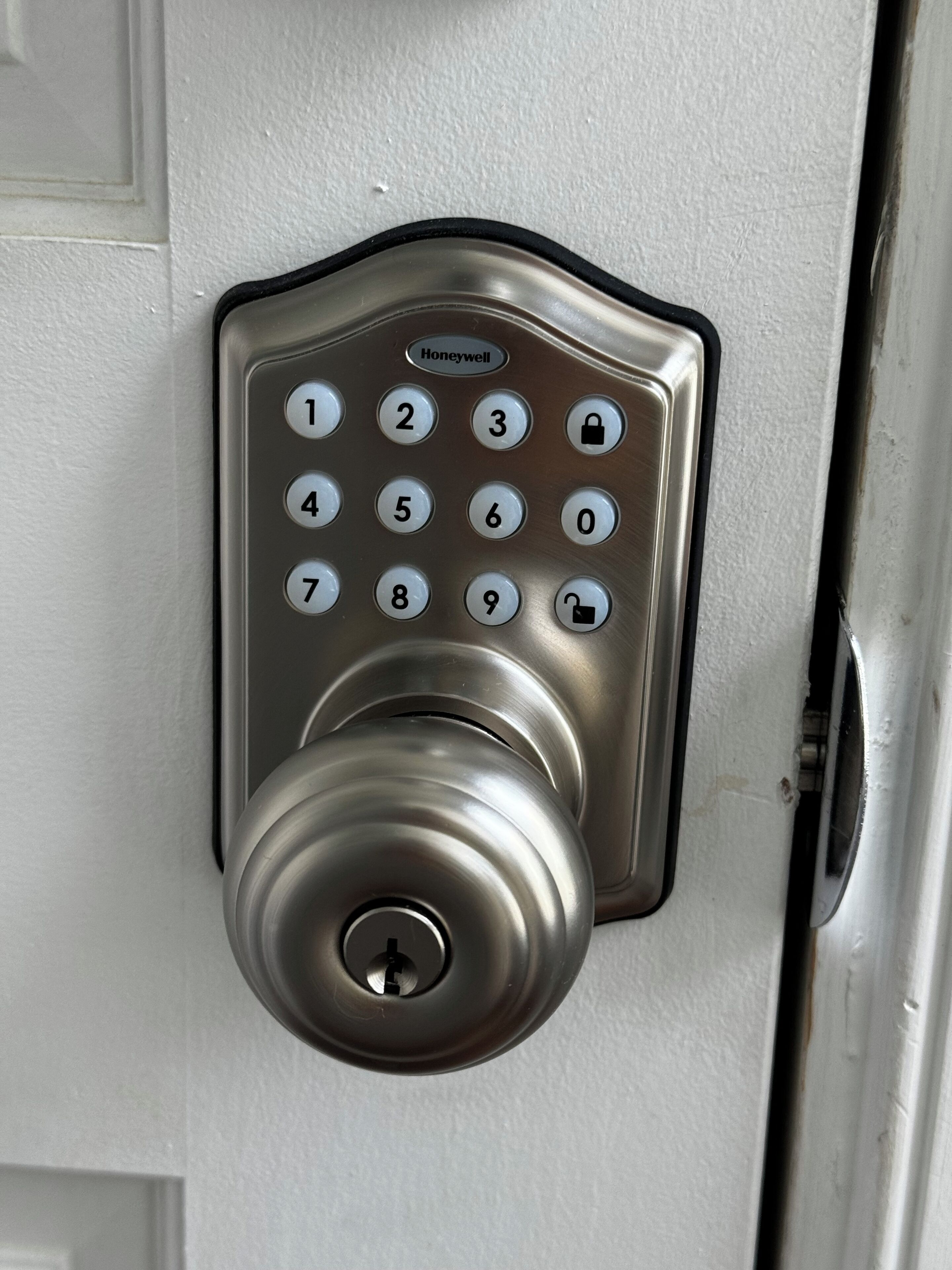 A numeric keypad door lock with a keyhole below it.