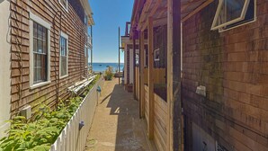 Un étroit sentier en bois, aménagé entre les bâtiments, offre une vue sur la mer.
