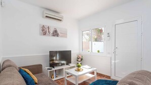 A modern living room with a flat-screen TV, a white coffee table, and a sofa with cushions. - Villa Canada (Tías)