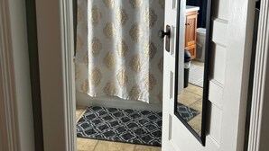 A bathroom with a shower curtain, a mirror, and a door. - A sweetheart home
3-bedroom vacation home, 6 minutes to Rivers Casino & Resort (Schenectady)