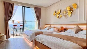 Habitación de hotel con dos camas, un balcón con vistas y un adorno en la pared.