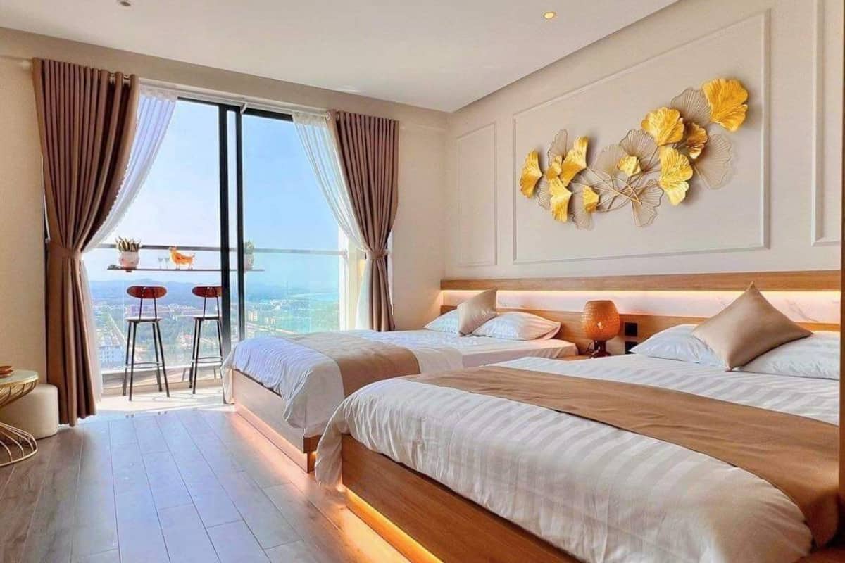 Habitación de hotel con dos camas, un balcón con vistas y un adorno en la pared.