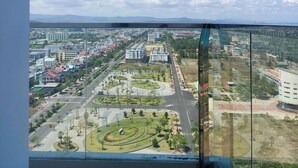 Un balcón con vistas despejadas de un paisaje urbano, incluyendo edificios, calles y un parque.