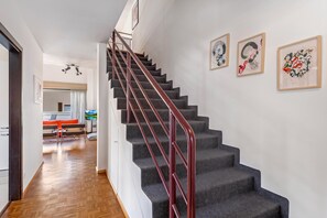 A staircase with a red handrail leading to a landing.