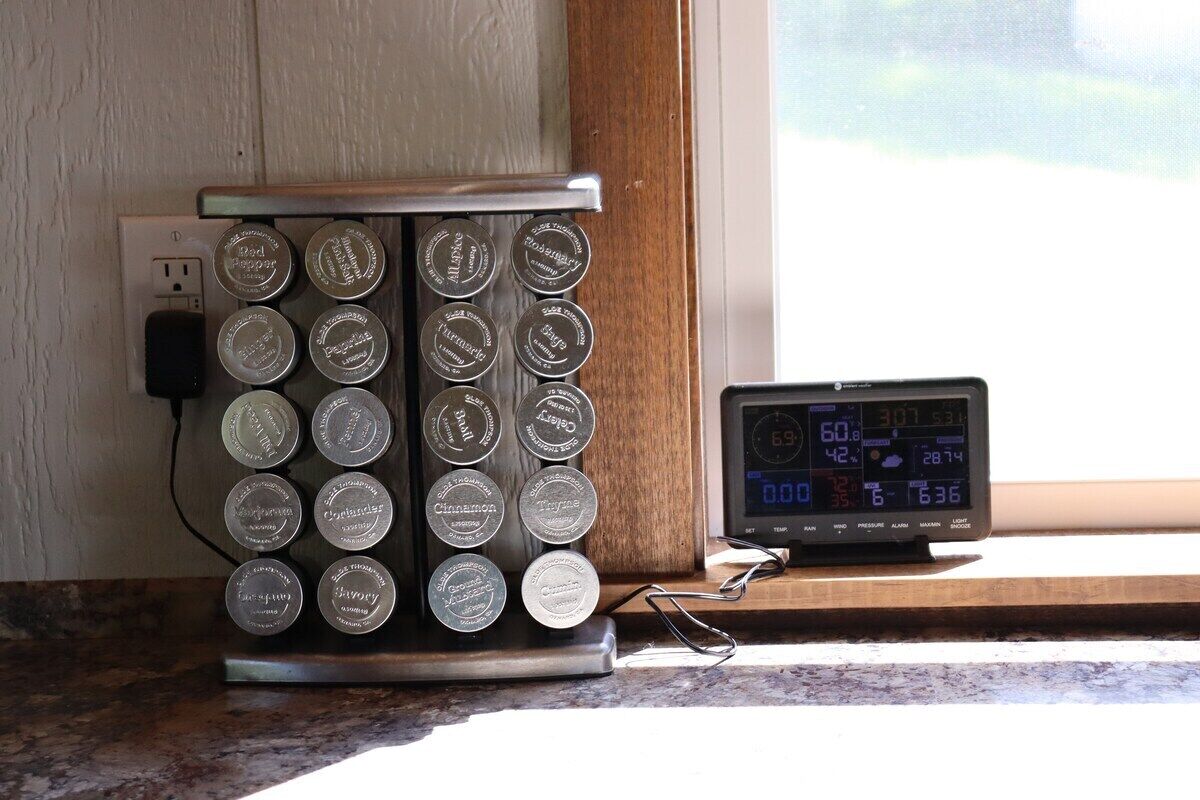 A kitchen with a coffee maker and a digital clock on the counter.