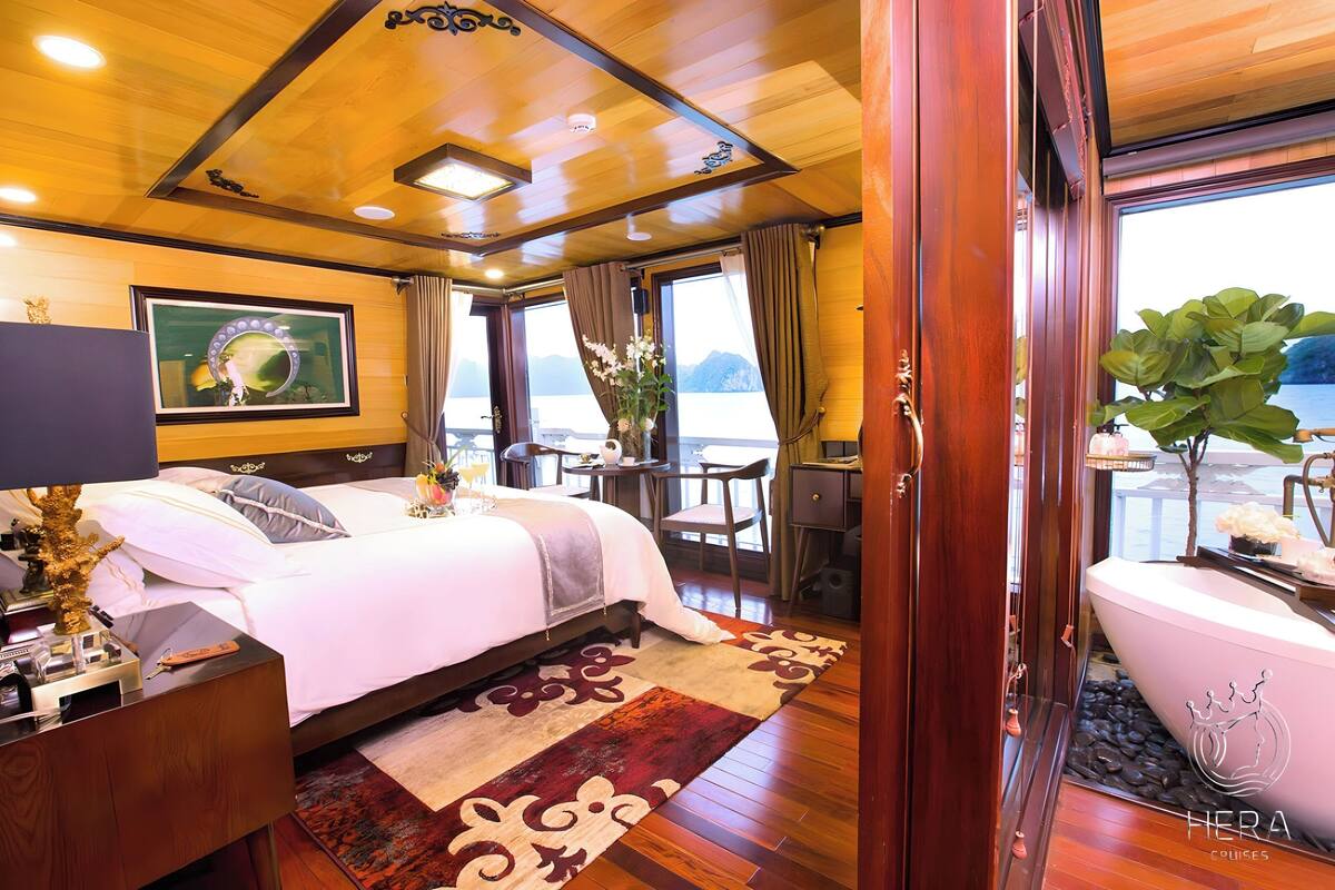 Ein luxuriöses Schlafzimmer mit einem großen Bett, einem Schminktisch und Meerblick.