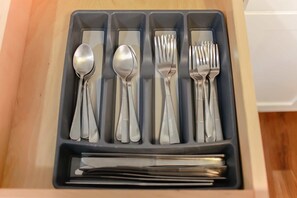 Eine Schublade mit Besteck, darunter Löffel, Gabeln und Messer.