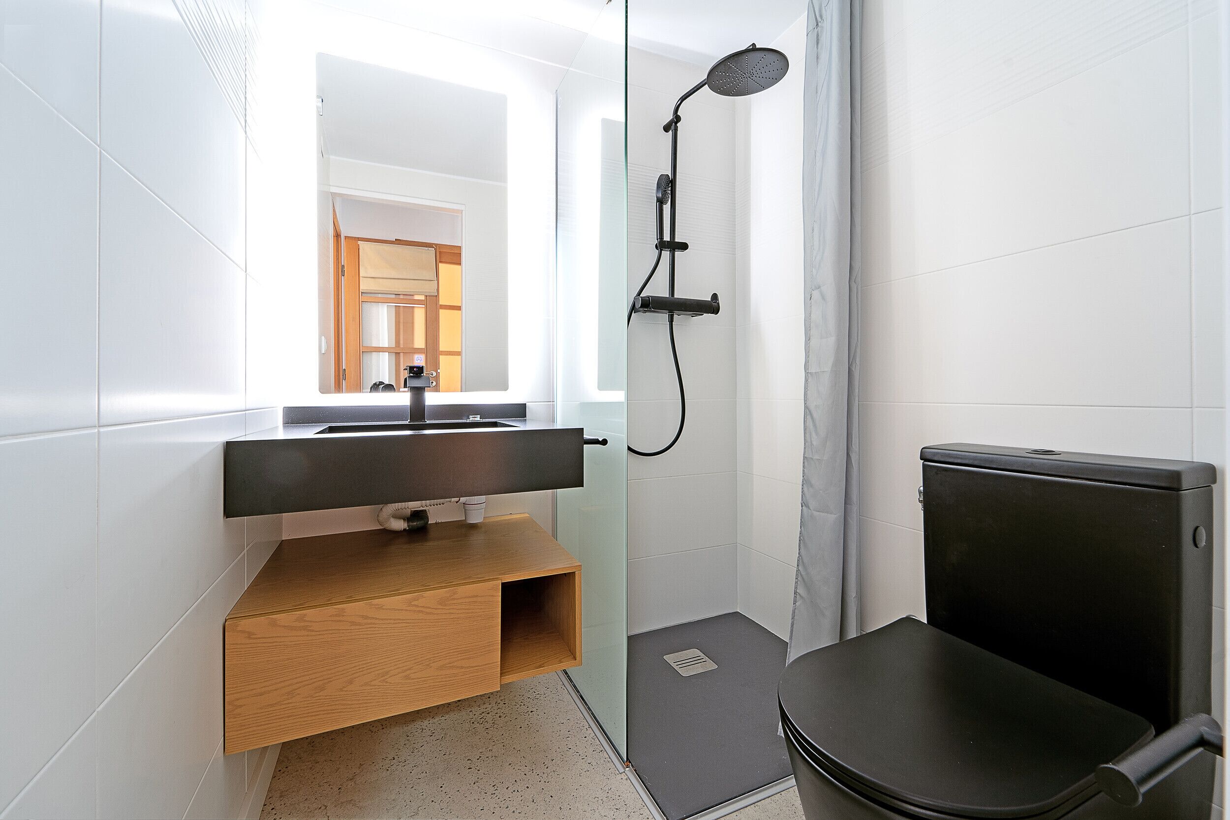 A modern bathroom with a shower, toilet, and sink.