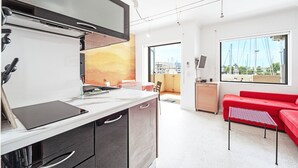 Een moderne keuken met een groot eiland, een rode bank en uitzicht op de haven.
